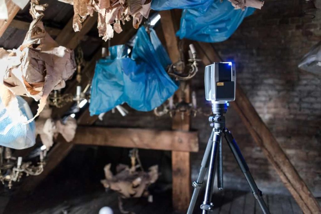 Laserscanner im Dachboden zwischen gelagertem Material