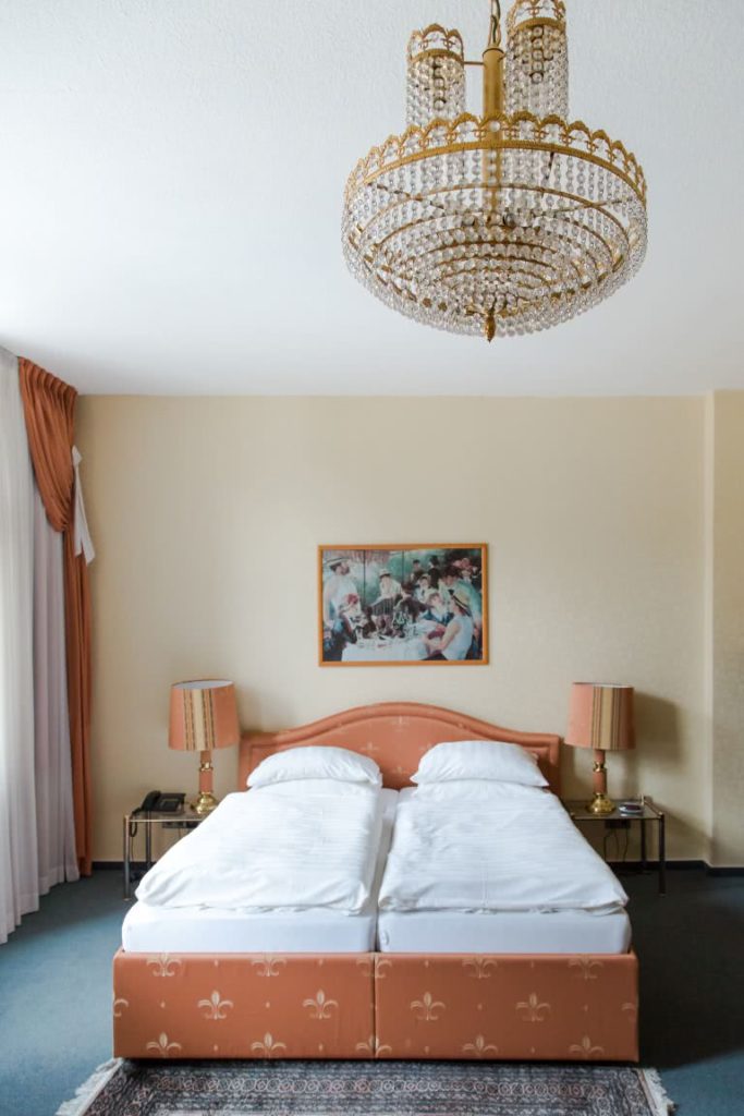 Hotelzimmer mit Kronleuchter und Doppelbett