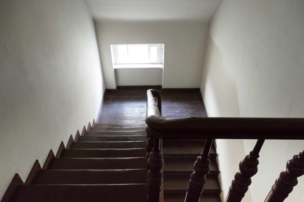 Schmales Nebentreppenhaus mit dunklem Geländer