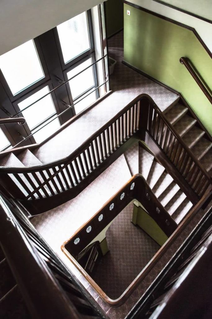 Blick von oben in das Treppenhaus mit Holzgeländer